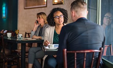 Cafe conversation: Business meeting with man and woman talking at restaurant.